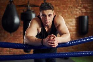 el joven boxeador con ropa deportiva tiene práctica en el gimnasio foto