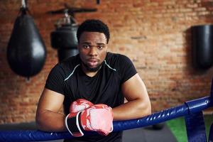 Strong african american boxer in sportive clothes have practice in the gym photo