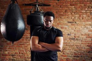 Strong african american man in sportive clothes standing in the gym photo