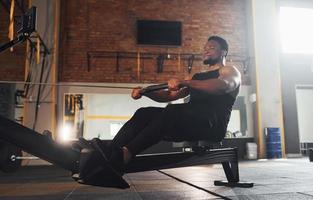 Strong african american man in sportive clothes have workout day in the gym by using equipment photo