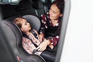 Mother with her daughter inside of modern automobile together photo