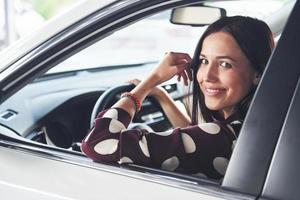 Beautiful young brunette inside of modern automobile. Riding car photo