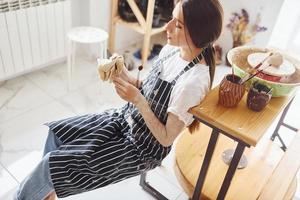 Young female ceramist indoors with handmade clay product. Conception of pottery photo