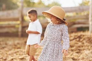 Cute little african american boy with european girl is on the farm photo