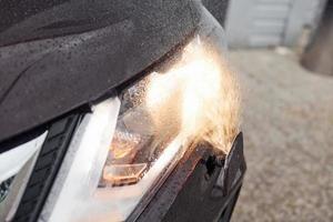 Front particle view of black modern automobile with headlights on photo