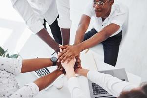 Top view of hands doing success gesture. Group of african american business people working in office together photo