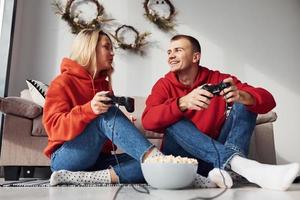 Young lovely couple together at home playing video games at weekend and holidays time together photo