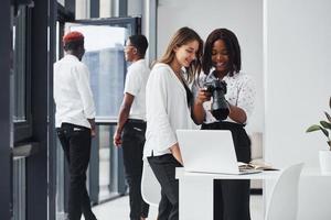 mujer probando la cámara. grupo de empresarios afroamericanos que trabajan juntos en la oficina foto