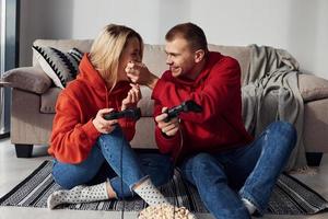 Young lovely couple together at home playing video games at weekend and holidays time together photo