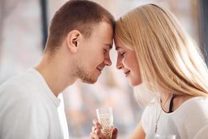 joven pareja encantadora juntos en casa con champán pasando el fin de semana y las vacaciones juntos foto