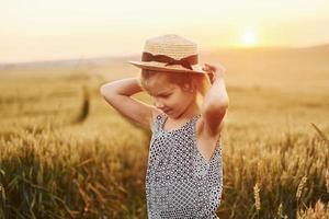 niña de pie en el campo agrícola a la hora de la tarde. concepción del tiempo libre de verano foto