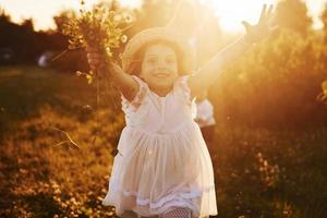 hermoso rayo de luz. madre con niño y niña pasando tiempo libre en el campo en un día soleado de verano foto