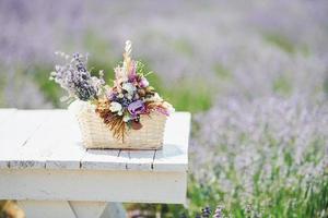 vista de cerca del ramo de flores de lavanda en la cesta que está sobre la mesa blanca en el campo foto