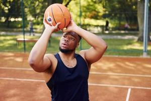 hombre afroamericano juega baloncesto en la cancha al aire libre foto