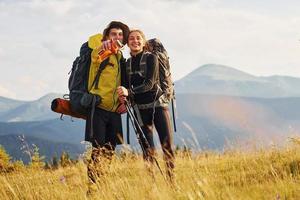 Beautiful young people travel together. Majestic Carpathian Mountains. Beautiful landscape of untouched nature photo