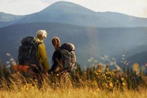 Beautiful young people travel together. Majestic Carpathian Mountains. Beautiful landscape of untouched nature photo