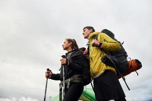 Young couple hiking outdoors together. Cloudy weather photo