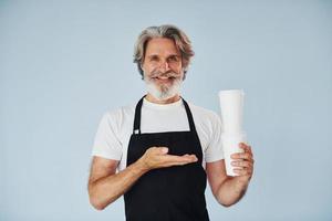 Waiter with drinks in hands. Senior stylish modern man with grey hair and beard indoors photo