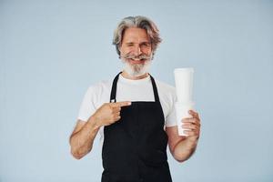 Waiter with drinks in hands. Senior stylish modern man with grey hair and beard indoors photo