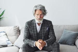 Conception of beautiful style. Senior stylish modern man with grey hair and beard indoors photo