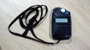 Light meter black color on the wood texture table and top view angle. photo