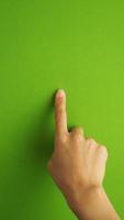 Human finger touching or pointing on green screen background and in studio. photo