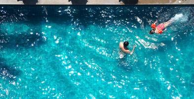 piscina y padre e hija y jugando juntos y momento de felicidad y vista superior. foto