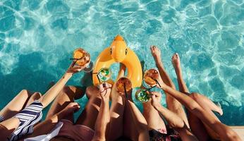 vista superior del grupo de jóvenes felices que se divierten en la piscina durante el día foto