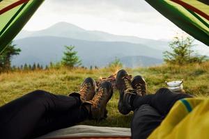 Man and woman inside of tent together. Majestic Carpathian Mountains. Beautiful landscape of untouched nature photo