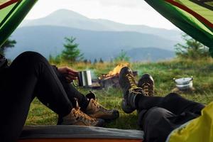 Man and woman inside of tent together. Majestic Carpathian Mountains. Beautiful landscape of untouched nature photo