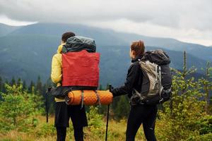 View from behind of young travelers. Majestic Carpathian Mountains. Beautiful landscape of untouched nature photo