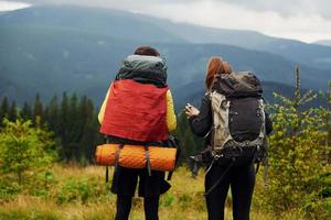 View from behind of young travelers. Majestic Carpathian Mountains. Beautiful landscape of untouched nature photo