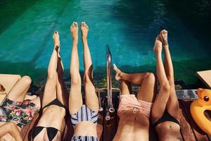 Taking a rest together. Group of young happy people have fun in swimming pool at daytime photo