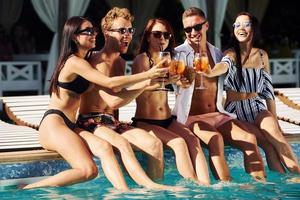 Group of young happy people have fun in swimming pool at daytime photo