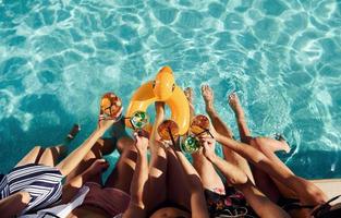 vista superior del grupo de jóvenes felices que se divierten en la piscina durante el día foto