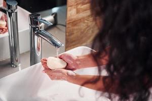 vista de cerca de la mujer que está de pie en el baño y se lava las manos foto