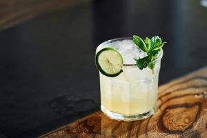 Green mint and yellow lime. Close up view of fresh summer cocktail on the wooden table photo