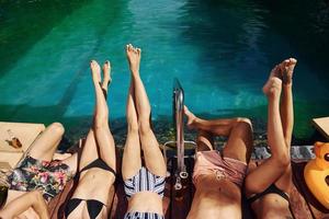 Taking a rest together. Group of young happy people have fun in swimming pool at daytime photo