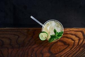 Green mint and yellow lime. Close up view of fresh summer cocktail on the wooden table photo