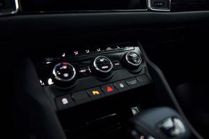 Knobs and buttons. Close up focused view of brand new modern black automobile photo