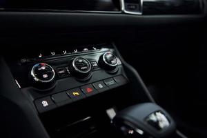 Knobs and buttons. Close up focused view of brand new modern black automobile photo