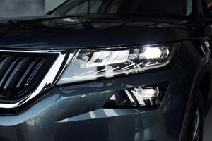 Headlight of car. Close up focused view of brand new modern black automobile photo