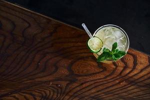 Green mint and yellow lime. Close up view of fresh summer cocktail on the wooden table photo