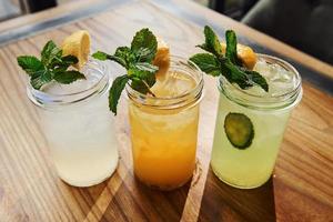 Yellow and green colored. Close up view of fresh summer alcoholic cocktails on the wooden table photo