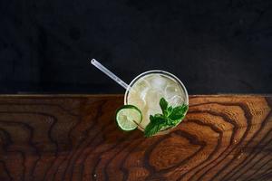 Green mint and yellow lime. Close up view of fresh summer cocktail on the wooden table photo