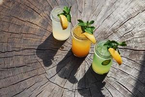 Yellow and green colored. Close up view of fresh summer alcoholic cocktails on the wooden table photo