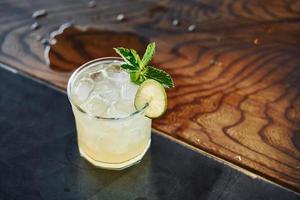 Green mint and yellow lime. Close up view of fresh summer cocktail on the wooden table photo