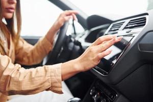 Side view of fashionable beautiful young woman that is inside her modern automobile photo