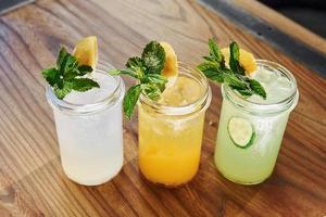 Yellow and green colored. Close up view of fresh summer alcoholic cocktails on the wooden table photo