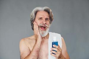 Fresh and clean face. Stylish modern senior man with gray hair and beard is indoors photo